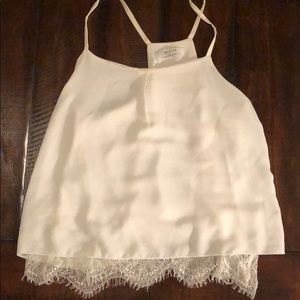 Dainty white tank top w lace detail.